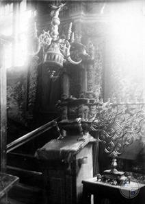 Интерьер синагоги в Берездовцах. На переднем плане резная деревянная бима, виден арон кодеш и росписи потолка