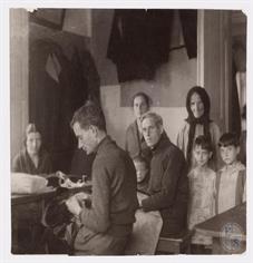 Дабровица. Портной и его семья: двое мужчин работают за столом, а женщины и дети позируют