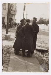 Пулавы. Четверо мужчин в традиционной одежде разговаривают на тротуаре