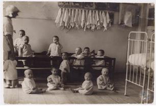 Варшава. Малыши в еврейском доме для сирот позируют в белых халатах за столом