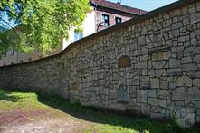 Стена кладбища собрана из осколков надгробных плит