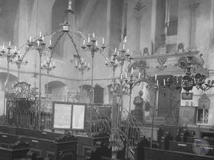 Интерьер синагоги, 1925. В центре бима, увенчанная короной и большим количеством светильников. На заднем плане виден резной деревянный шкаф