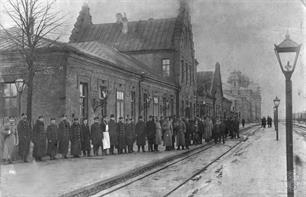 Железнодорожники и служащие возле старого вокзала, на заднем плане виден новый вокзал