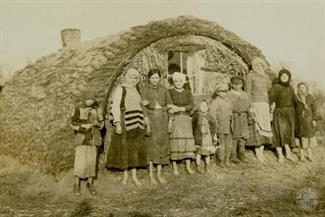 Jewish family that had been forced to flee their town pose outside their temporary home, a crude structure located on the road between Kovel and Riwne. Photographer Max Colton, Joint Distribution Committee, 1914-1918